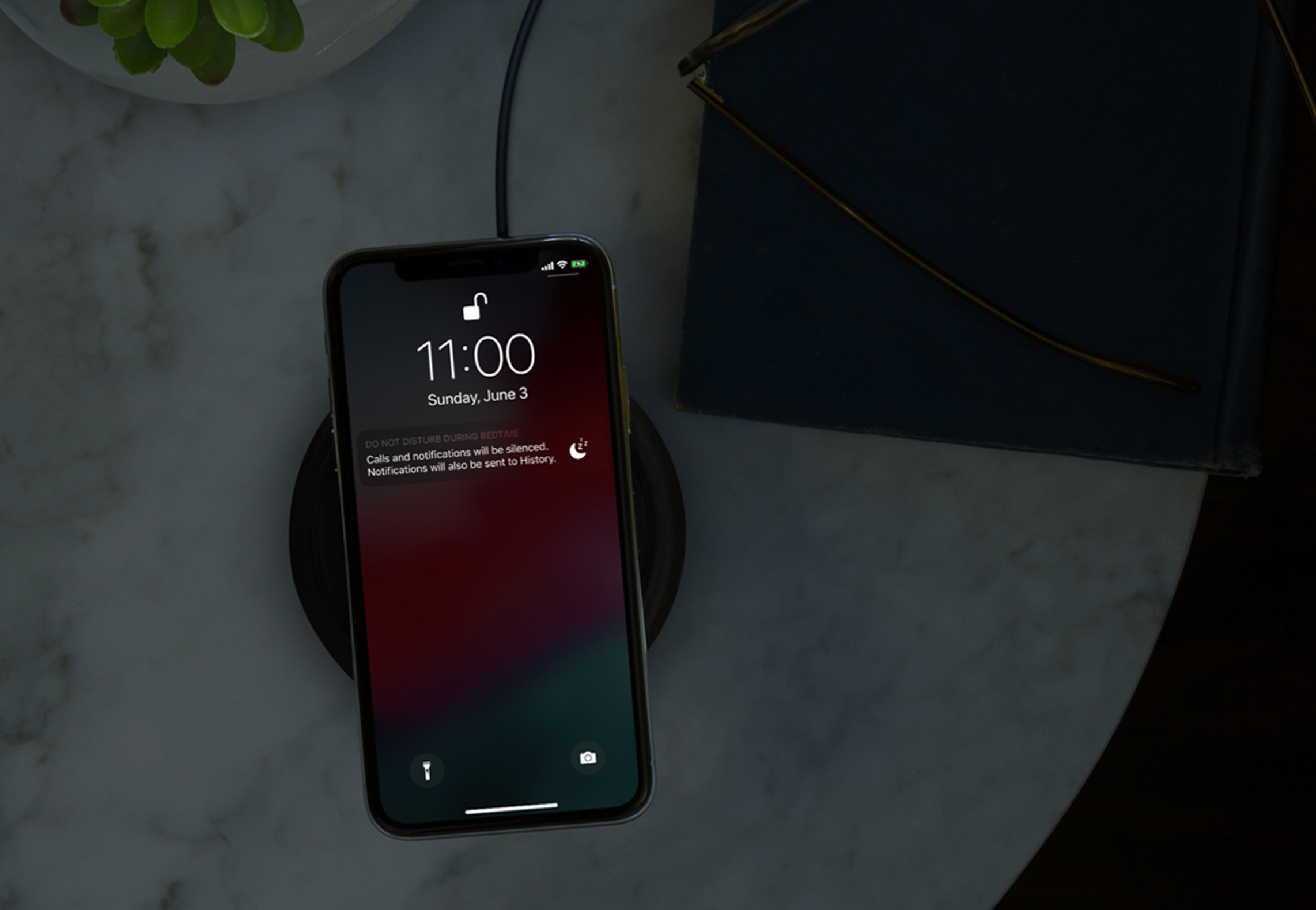 An Apple iPhone X on a wireless charging pad.