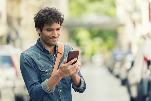 A young man checks his smartphone.