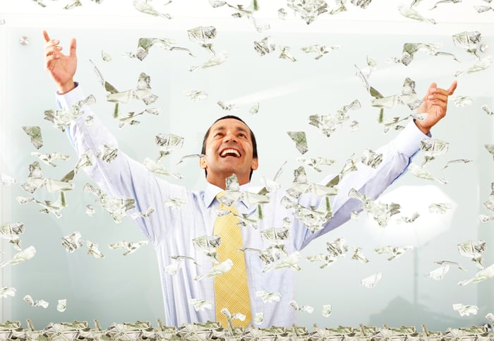 Money falling on a very happy person.