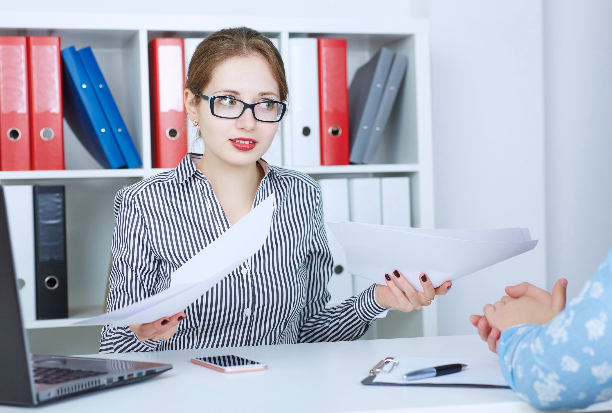 Female professional holding papers with rude expression on her face