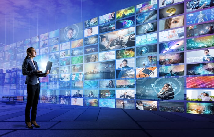 Woman standing in front of numerous screens