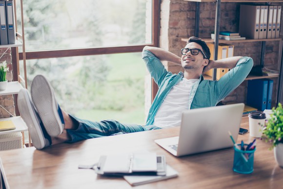 Man with relaxed expression and feet on desk.