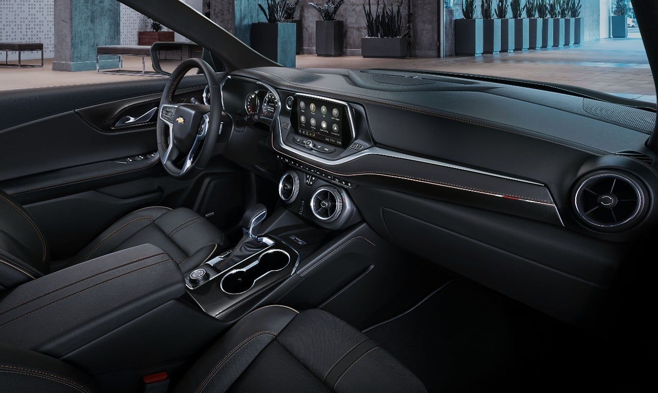 A view of the front seat and dash of a 2019 Chevrolet Blazer, featuring dark leather and fabric with brushed-metal accents.
