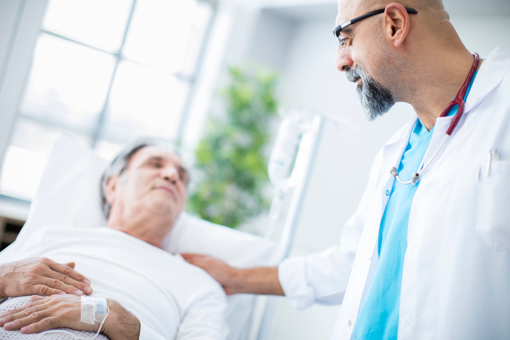 Doctor putting his hand on and elderly patient