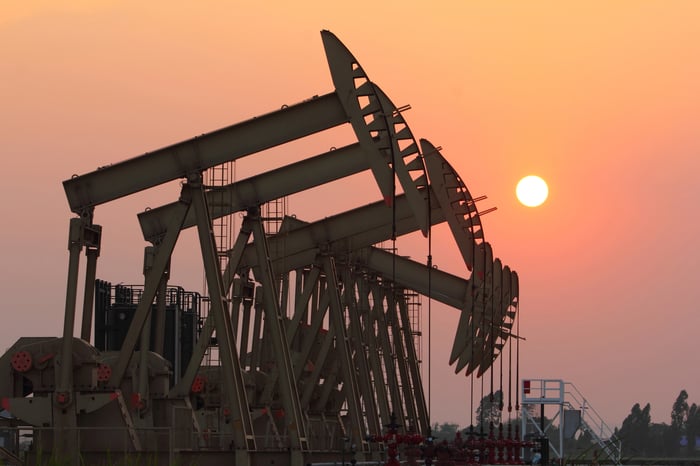 A group of oil pumps with the sun setting