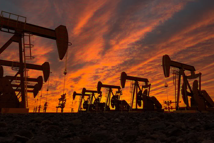 Rows of oil pumps under a twilight sky