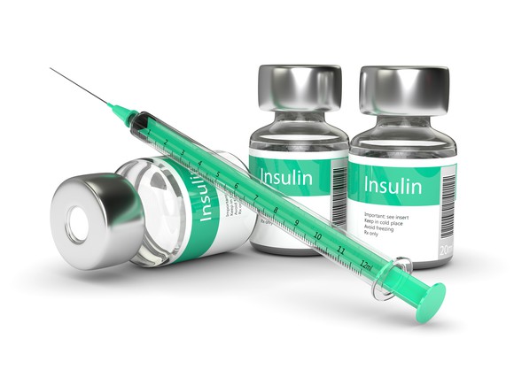 Insulin bottles and a syringe on a table