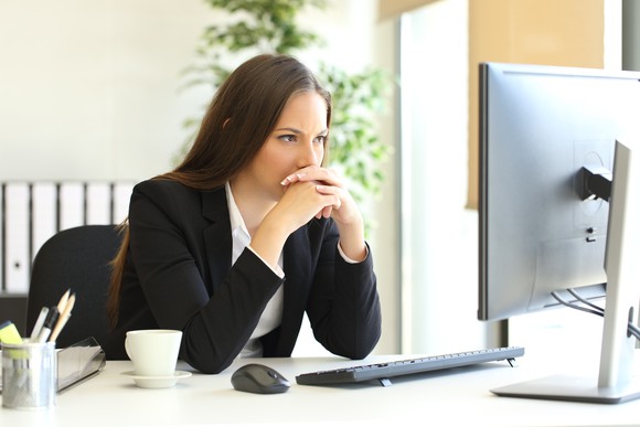 Professional woman at computer with angry expression