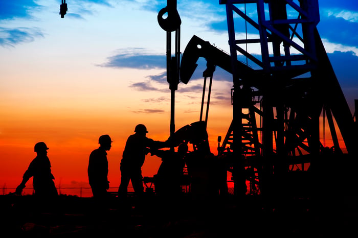 Oil field workers near a drilling rig.