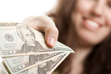 Woman handing over three $20 bills