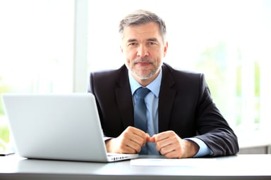 older man in suit at laptop_GettyImages-909286824