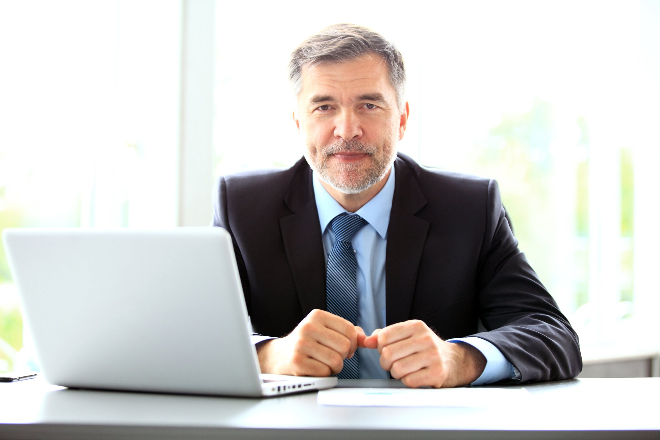 Older man in suit at laptop