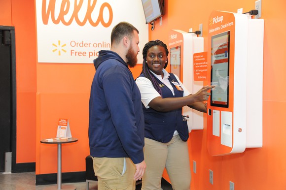 A Walmart associate helping a customer with an in-store pickup. 