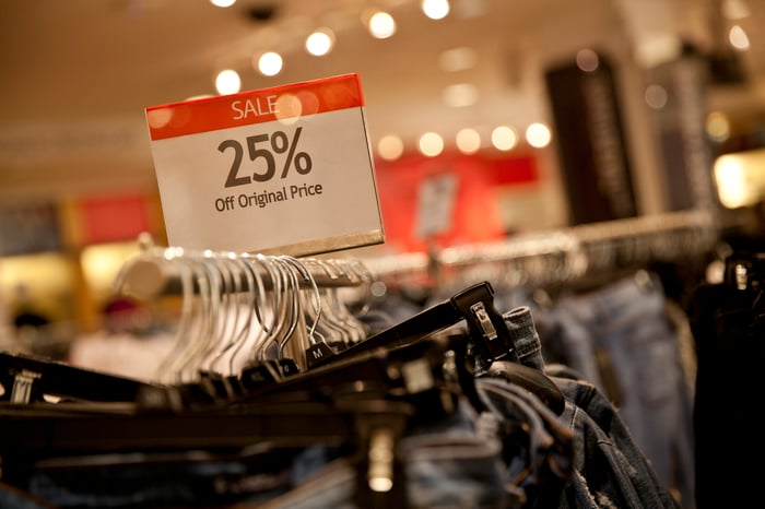 A 25%-off sign on a rack of jeans.
