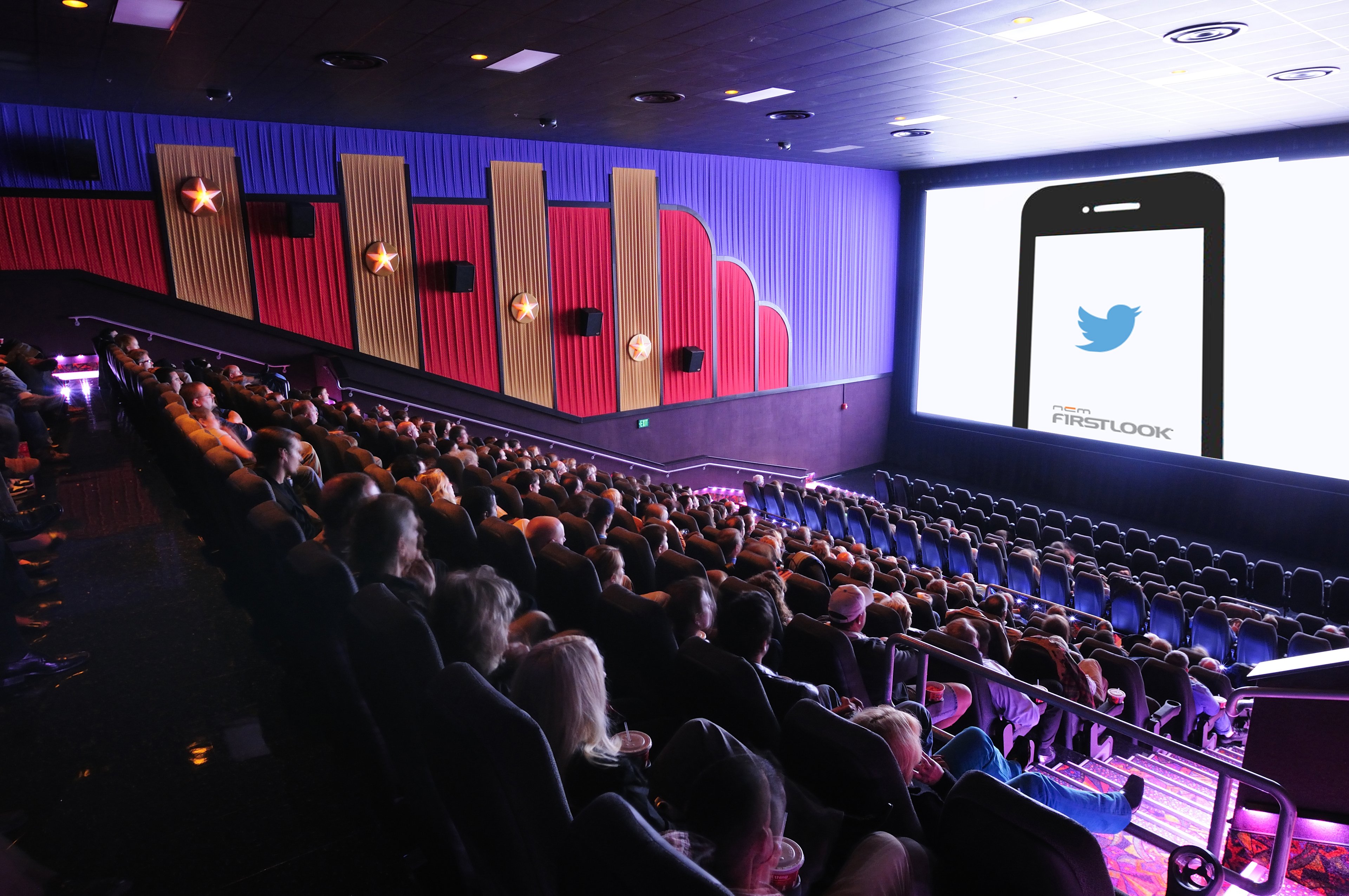 A movie theater filled to capacity, showing the logo of National CineMedia's FirstLook service on the screen.