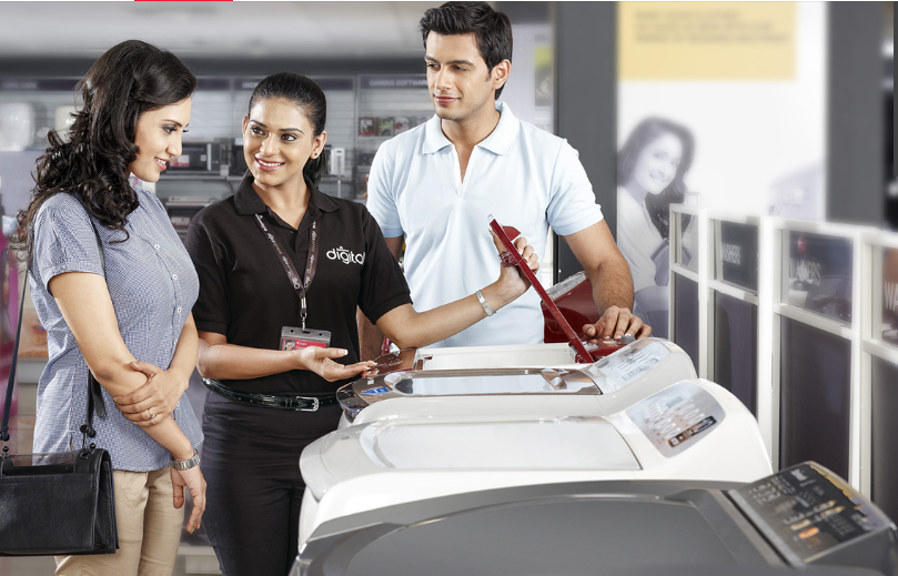 Customers checking out washing machines in a Reliance Digital store.