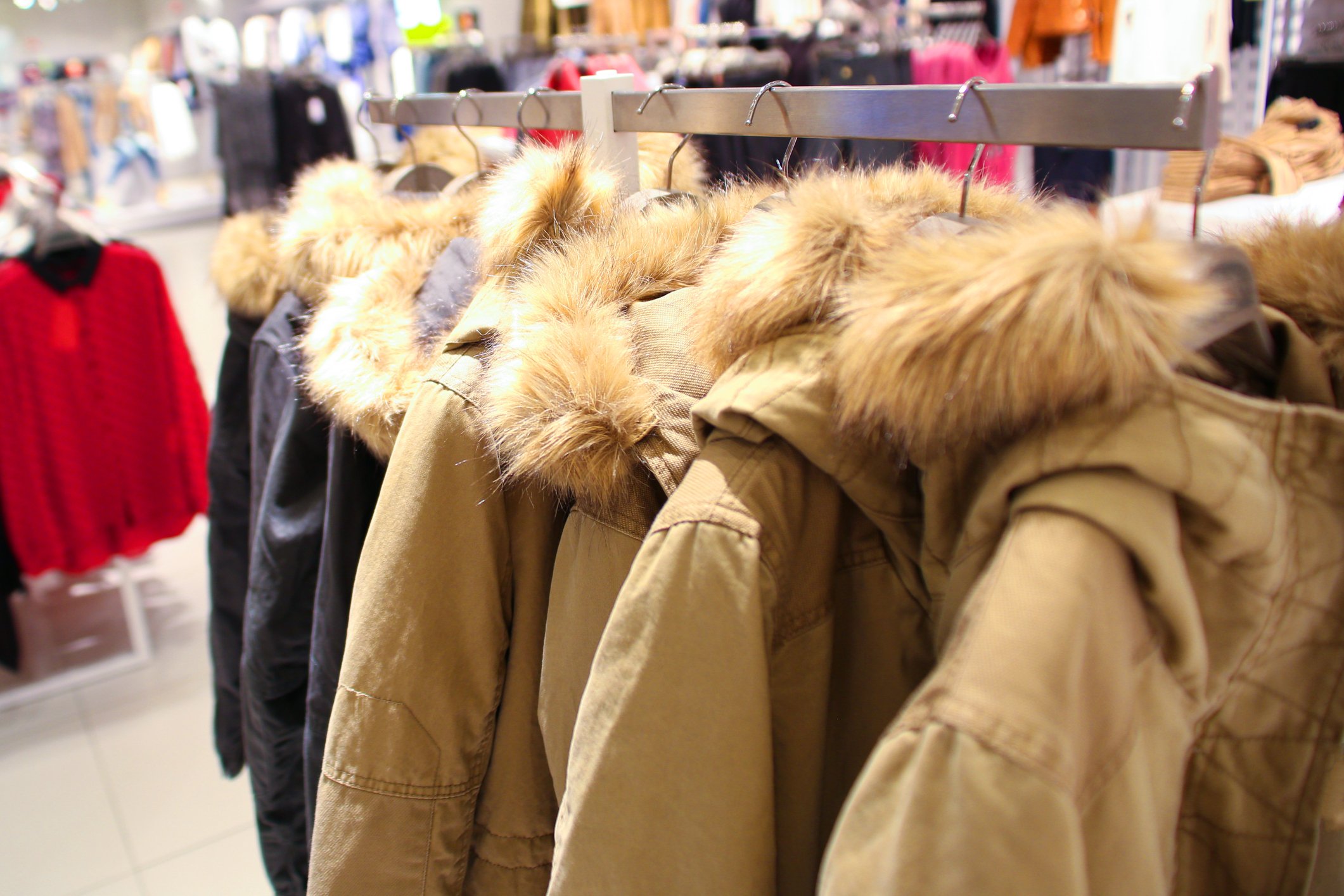 Winter coats on hangers in a store.