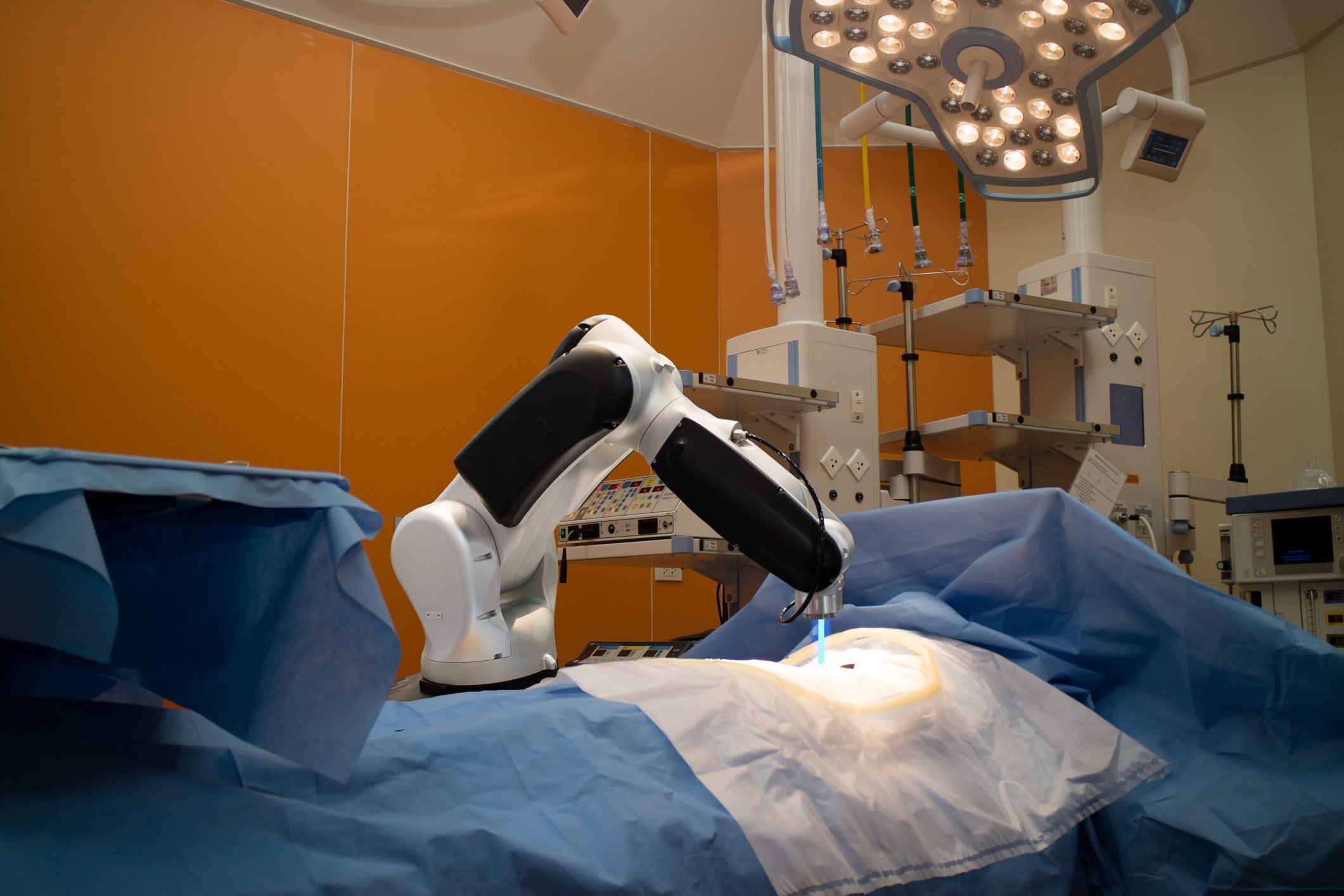 A robotic surgery tool, no unlike the daVinci system, performing surgery on a patient's abdomen.