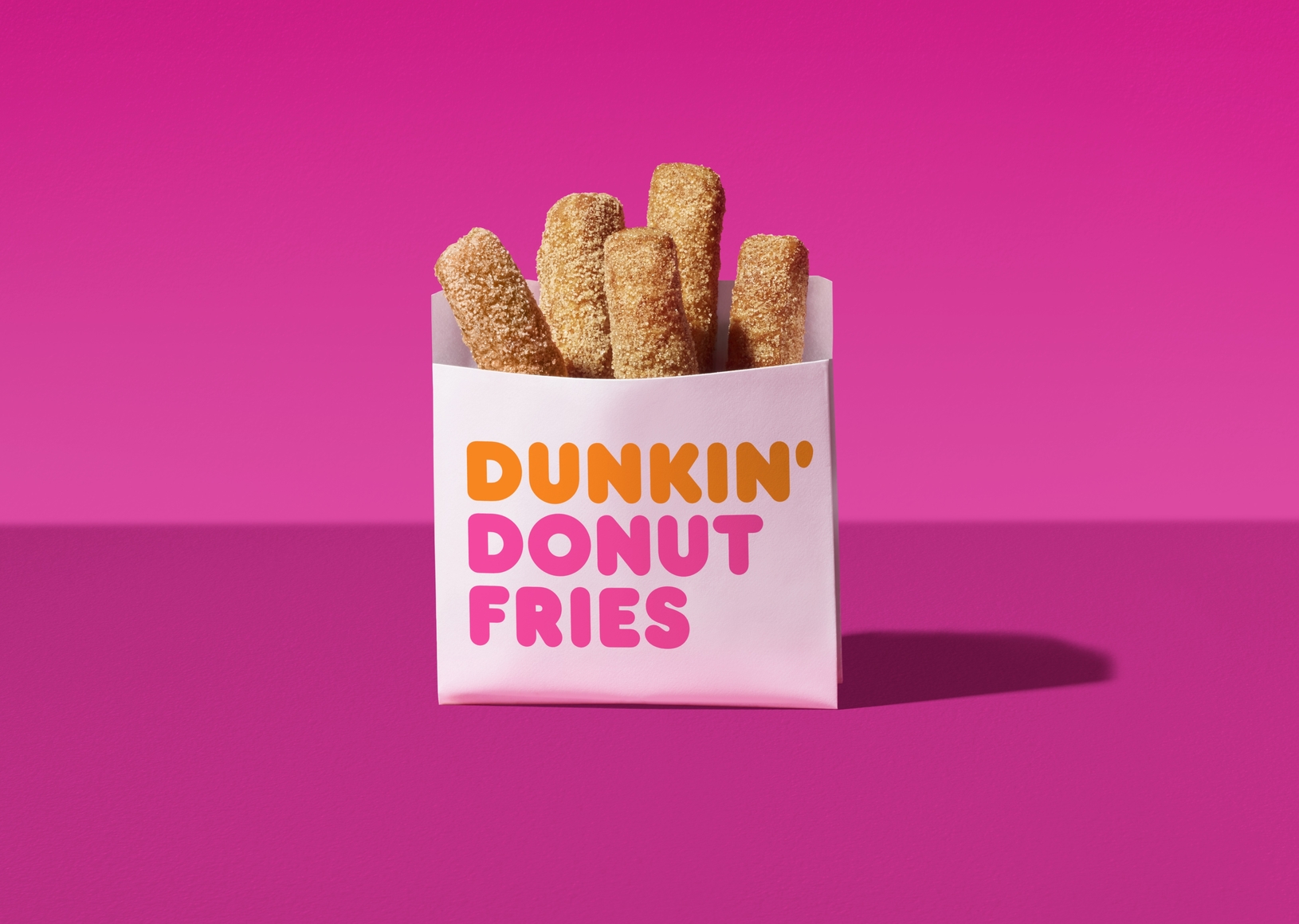 A bag of Dunkin' Donut Fries against a mauve backdrop.