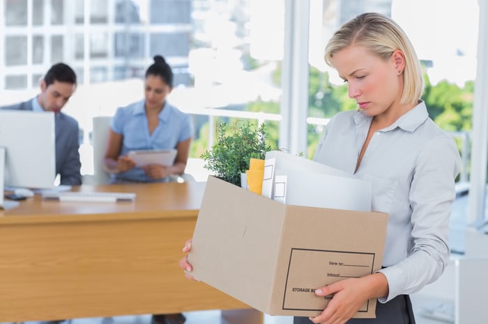 Woman carrying a cardboard box of office supplies