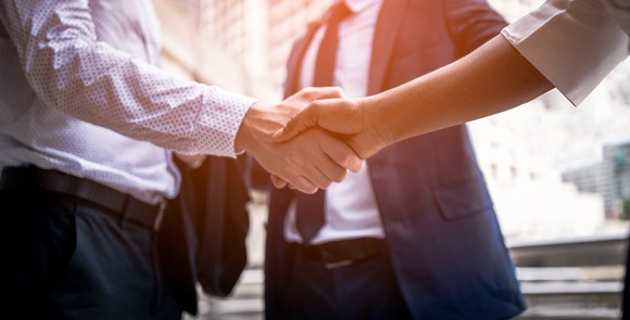Two people in business attire shaking hands