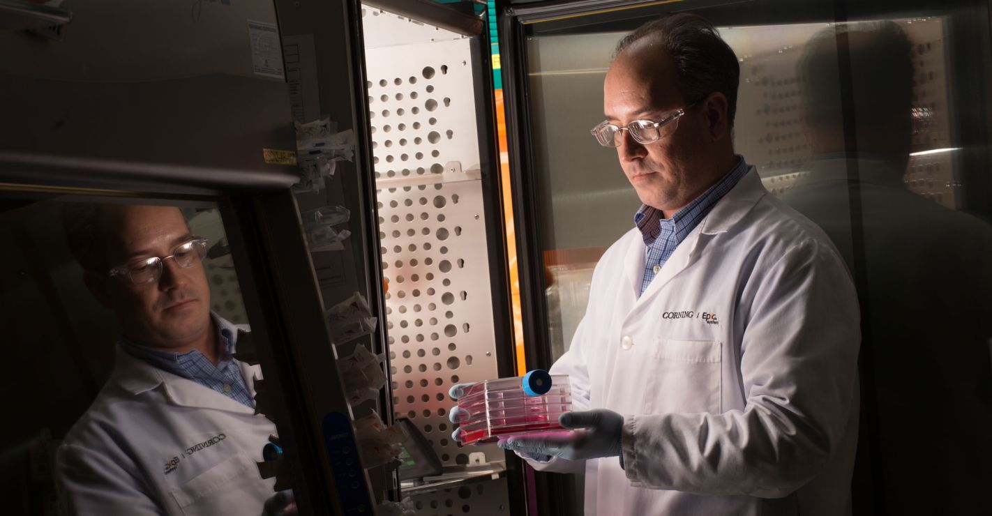 Corning scientist holding laboratory glass products