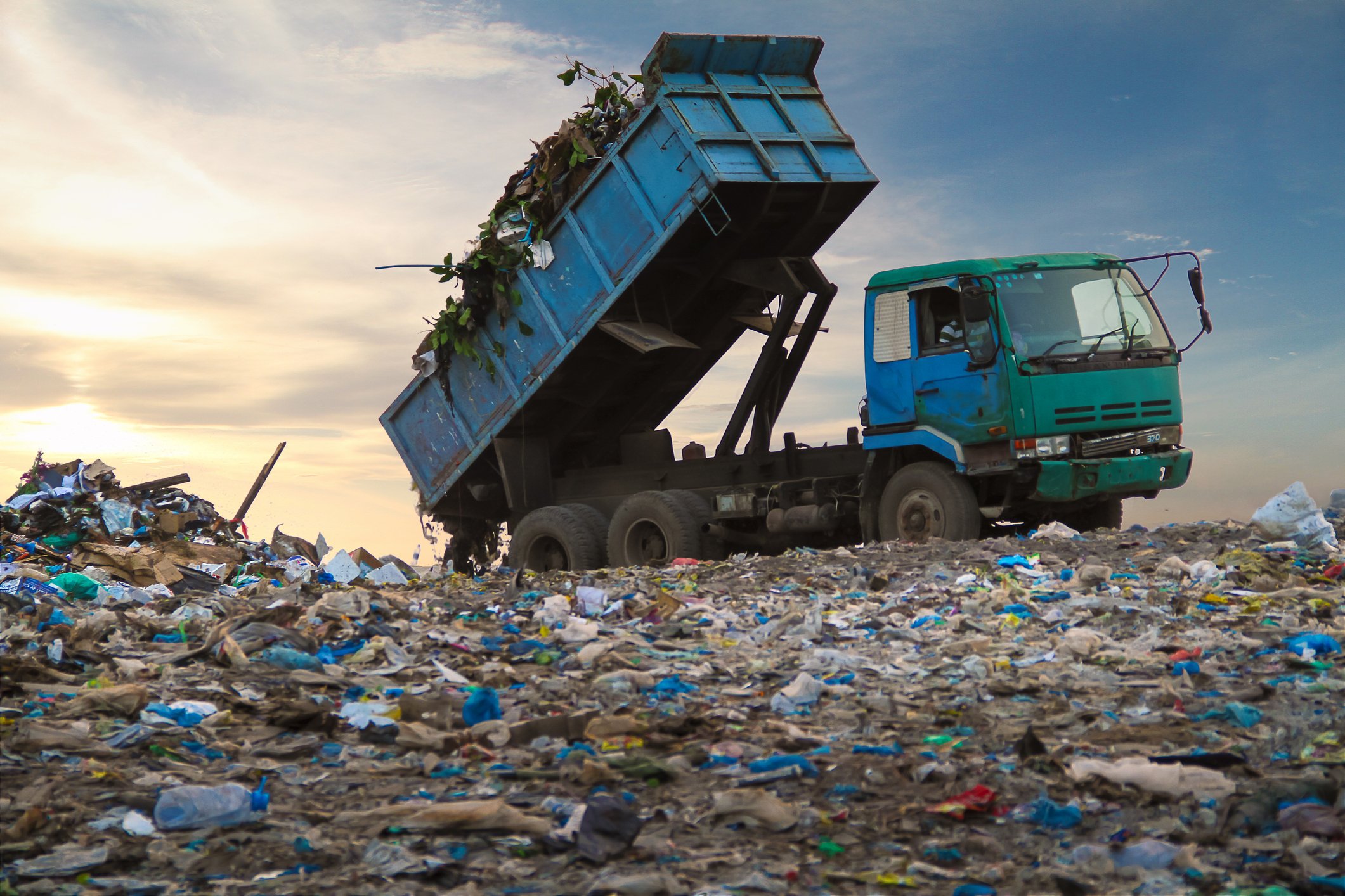 A garbage truck dumping a load at a landfill.