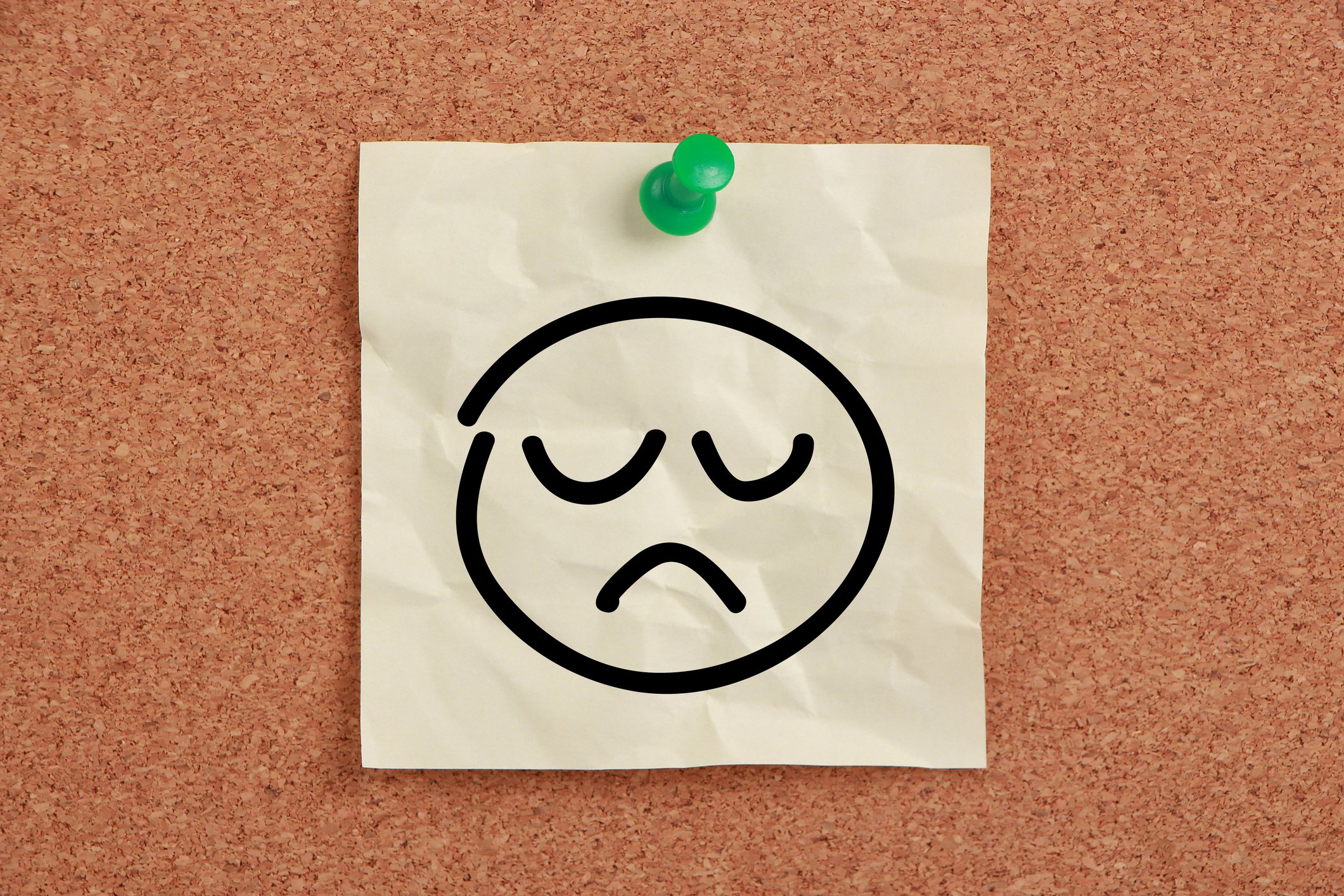 Drawing of sad face pinned to board