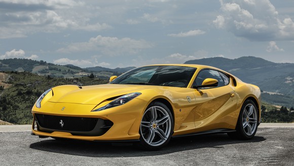 A yellow Ferrari 812 Superfast, a low-slung and sharply-styled two-seat sports car.
