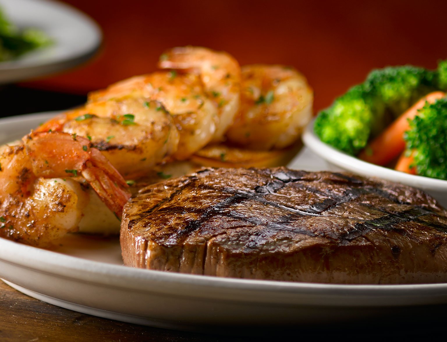 A plate of steak, shrimp, and vegetables.