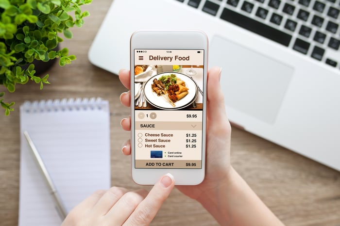 A customer orders food for delivery using a smartphone.