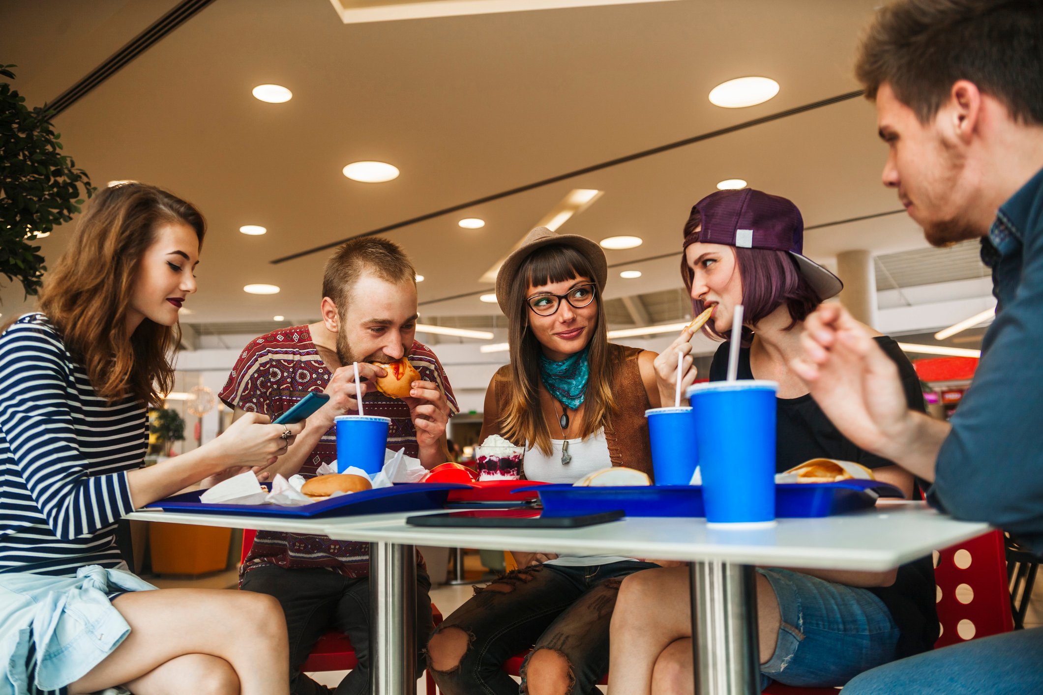 Five young adults eating a fast food meal.