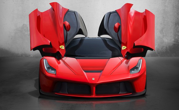 Red Ferrari with upward-opening doors in open position.