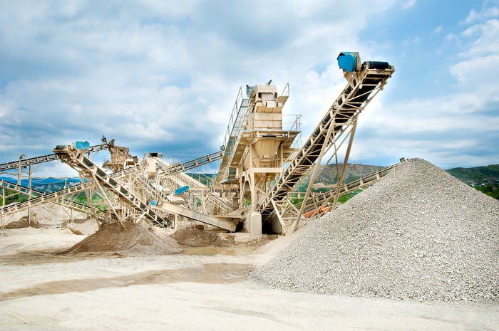 Sand mine equipment next to piles of sand