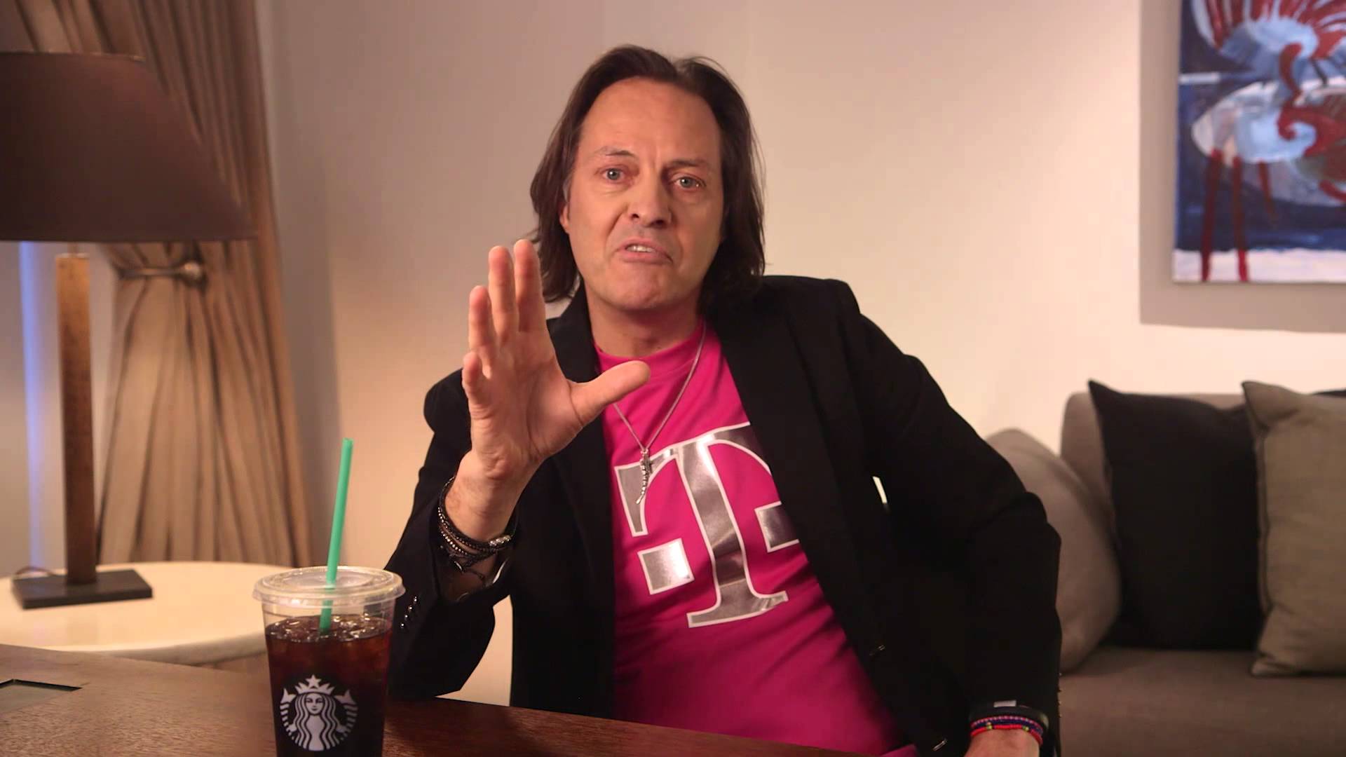 T-Mobile US CEO John Legere sitting at a table