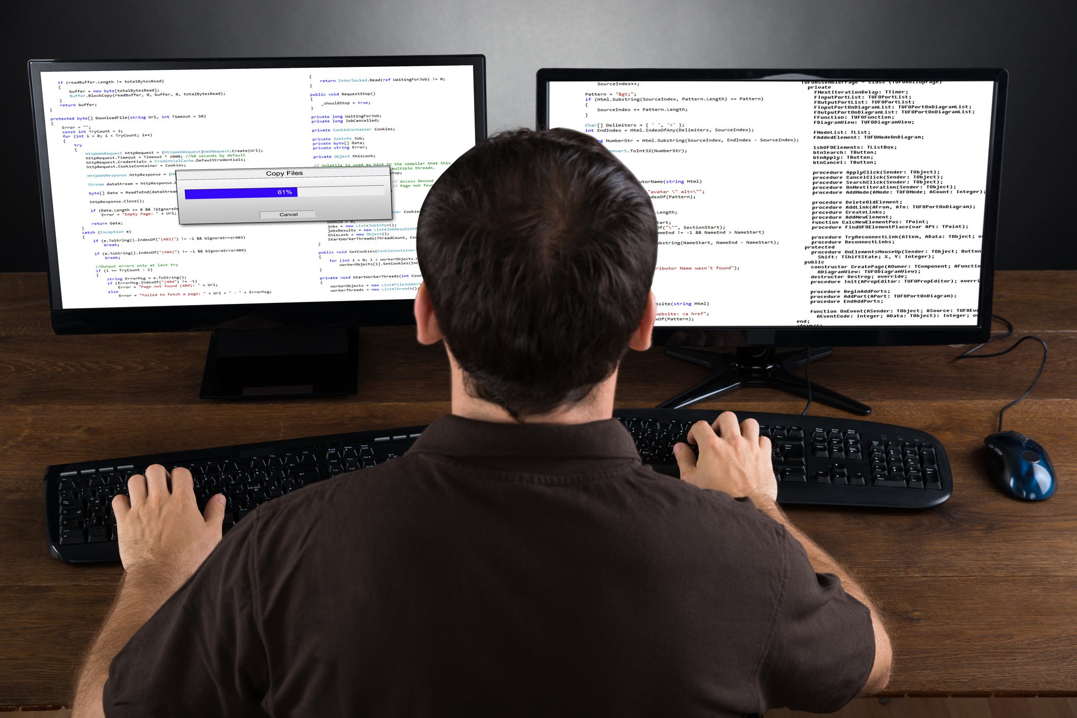 Man sitting at computer with two monitors