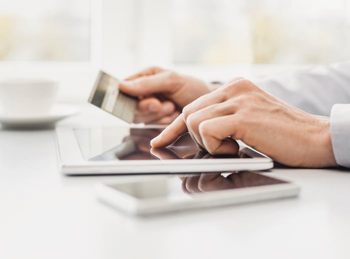 Man enters credit card number on a tablet computer.