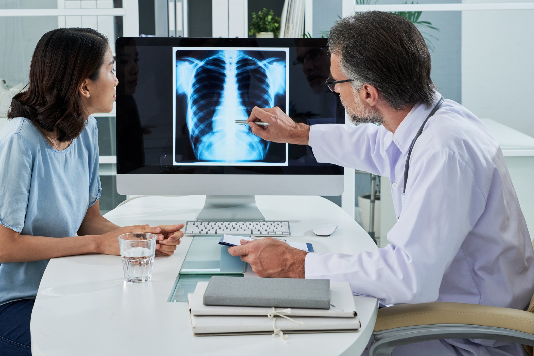 Doctor showing a chest x-ray on a computer to a patient