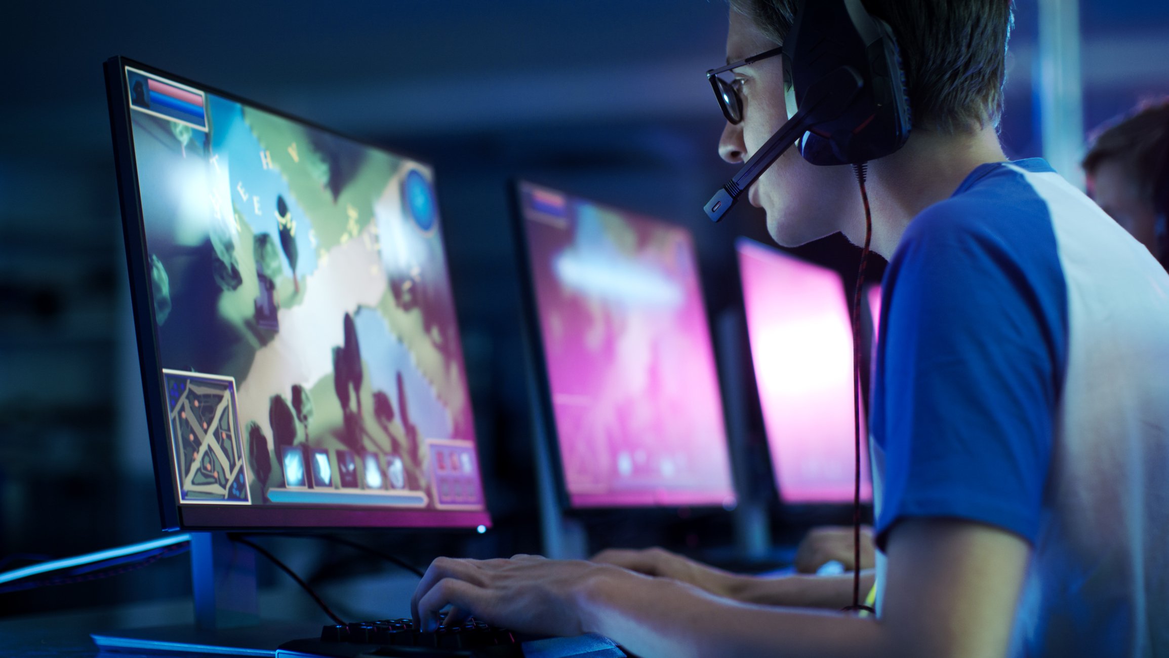 A young man wearing a headset playing a computer game.