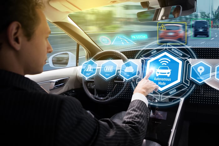 Man activating self-driving mode on car