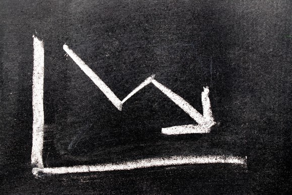 A chalkboard drawing of an arrow headed down.