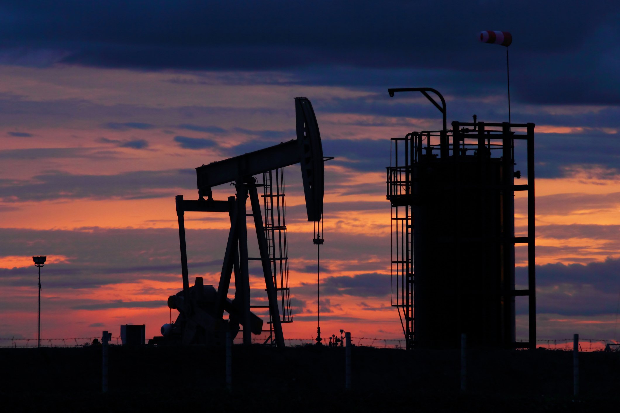 An oil pump with a sunny sky in the background.
