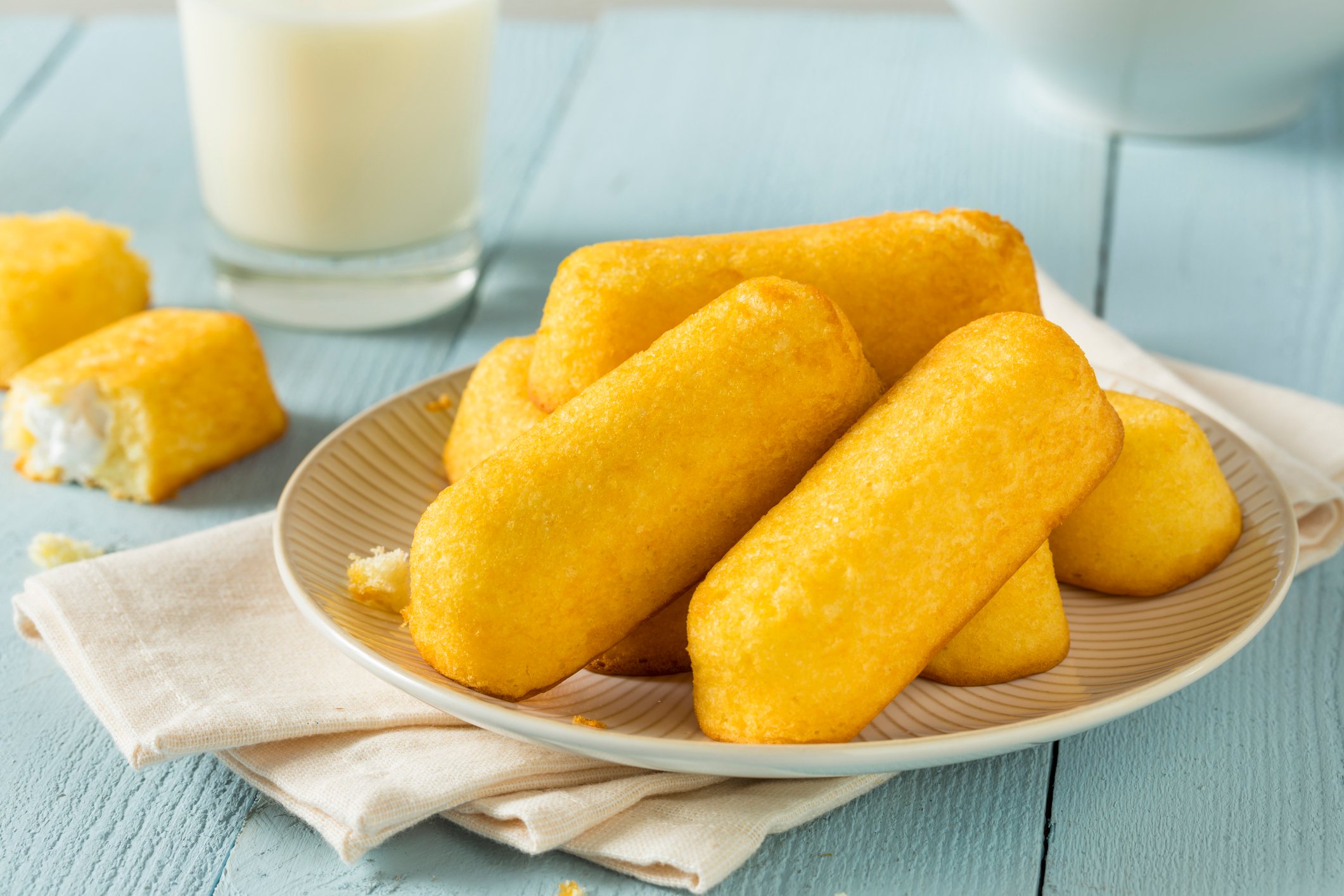 Yellow snack cakes piled up on a plate.