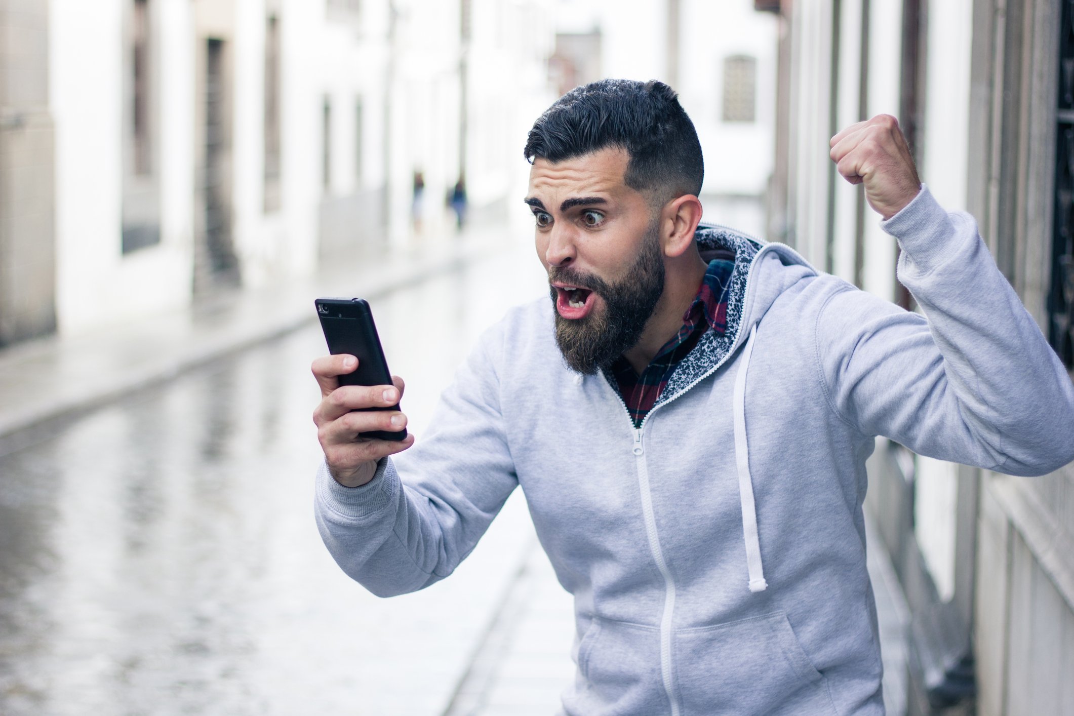Bearded man yelling at cellphone
