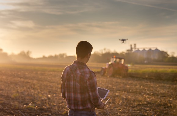 A farmer piloting a drone on his farm.