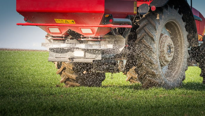 A tractor spreading fertilizer on a field.