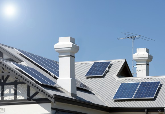Several solar panels installed on multiple facets of a residential roof.