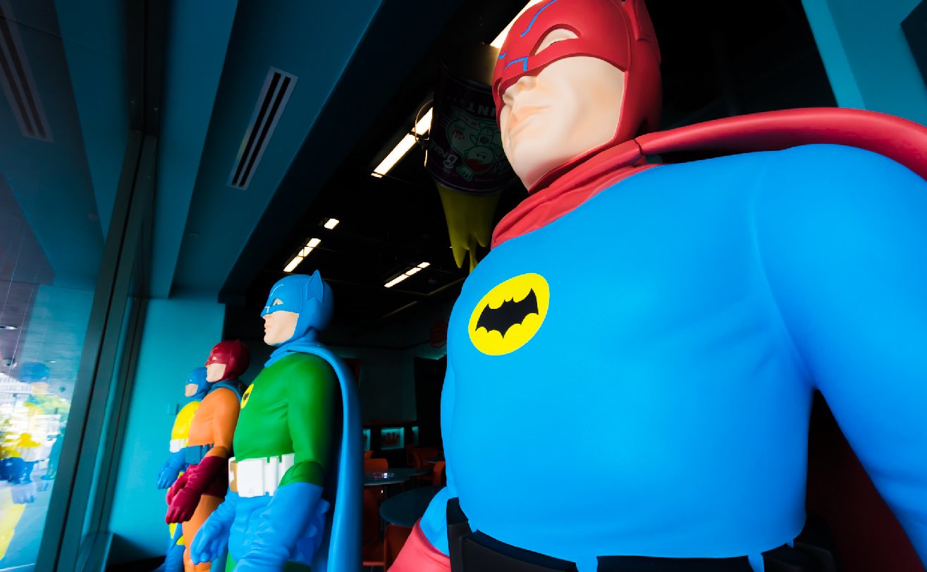 Colorful Batman and Robin mannequins displayed in headquarters window.