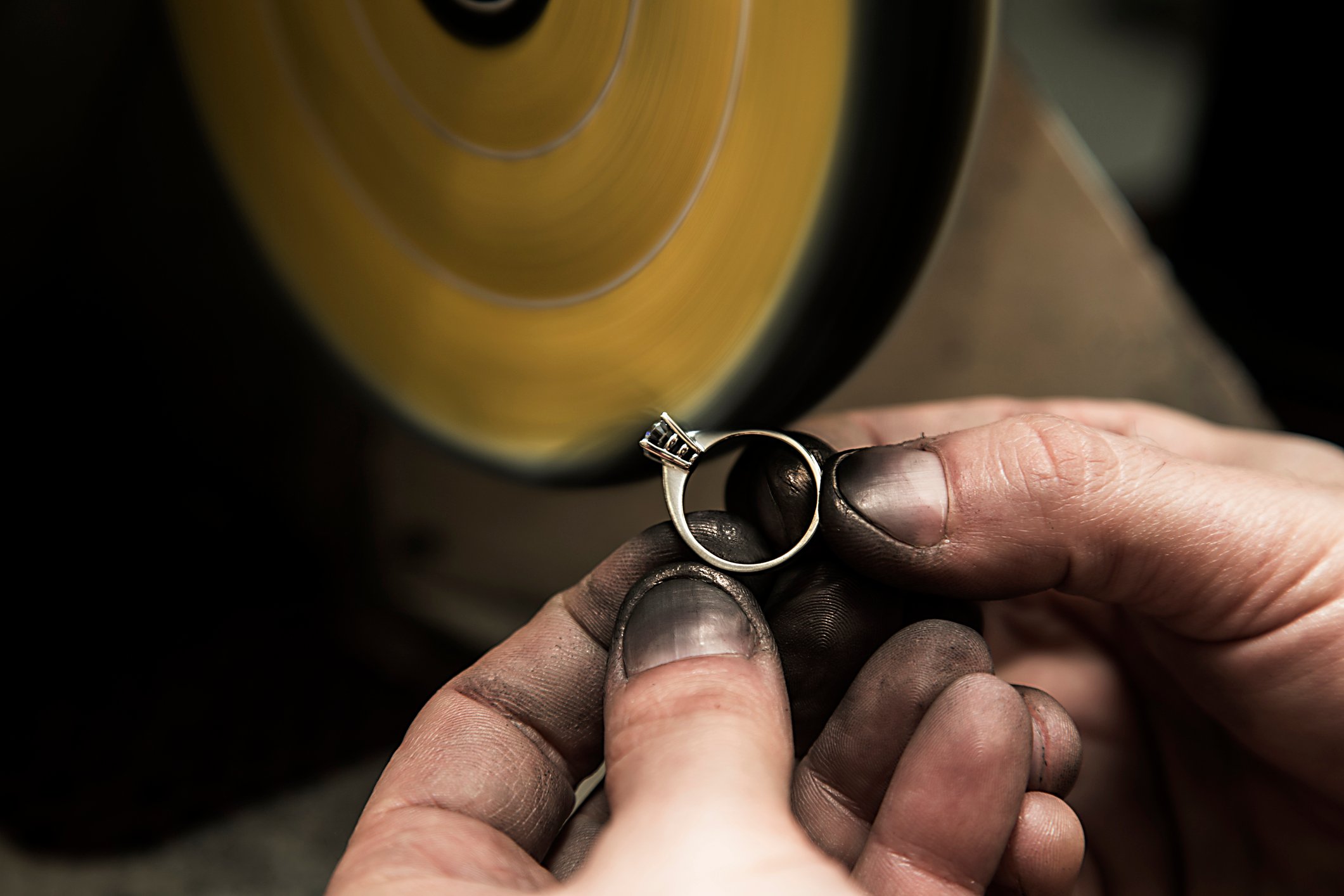 Jeweler polishing a diamond ring.