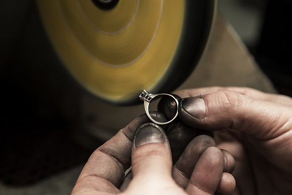 Jeweler polishing a diamond ring.